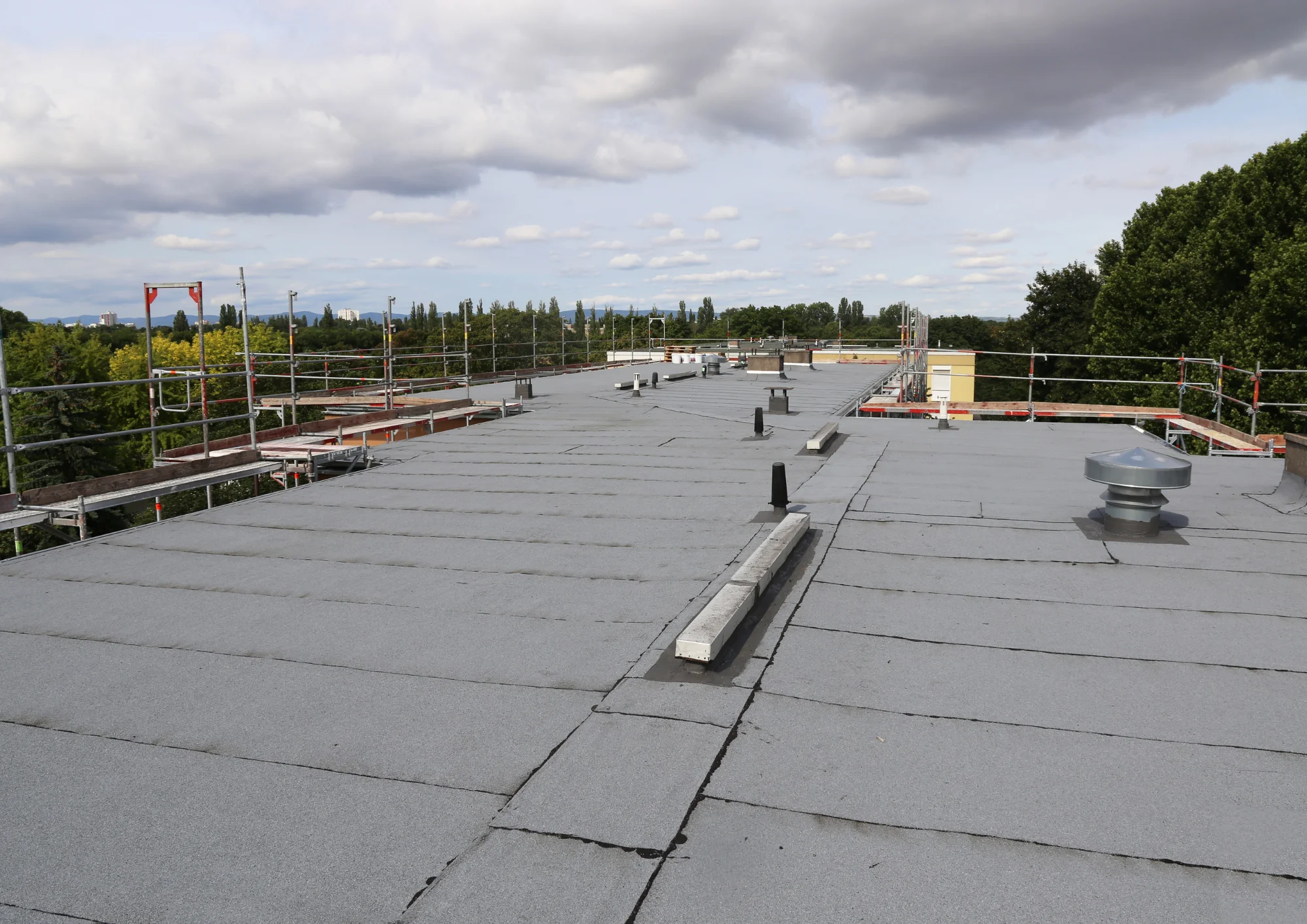 Flat roof showing signs of wear and potential leak areas, roofing inspection by Above All Roofing