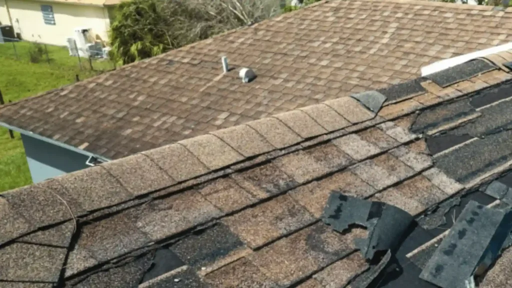 Roof with severely lifted and missing shingles after a storm in Rochester MN requiring immediate inspection