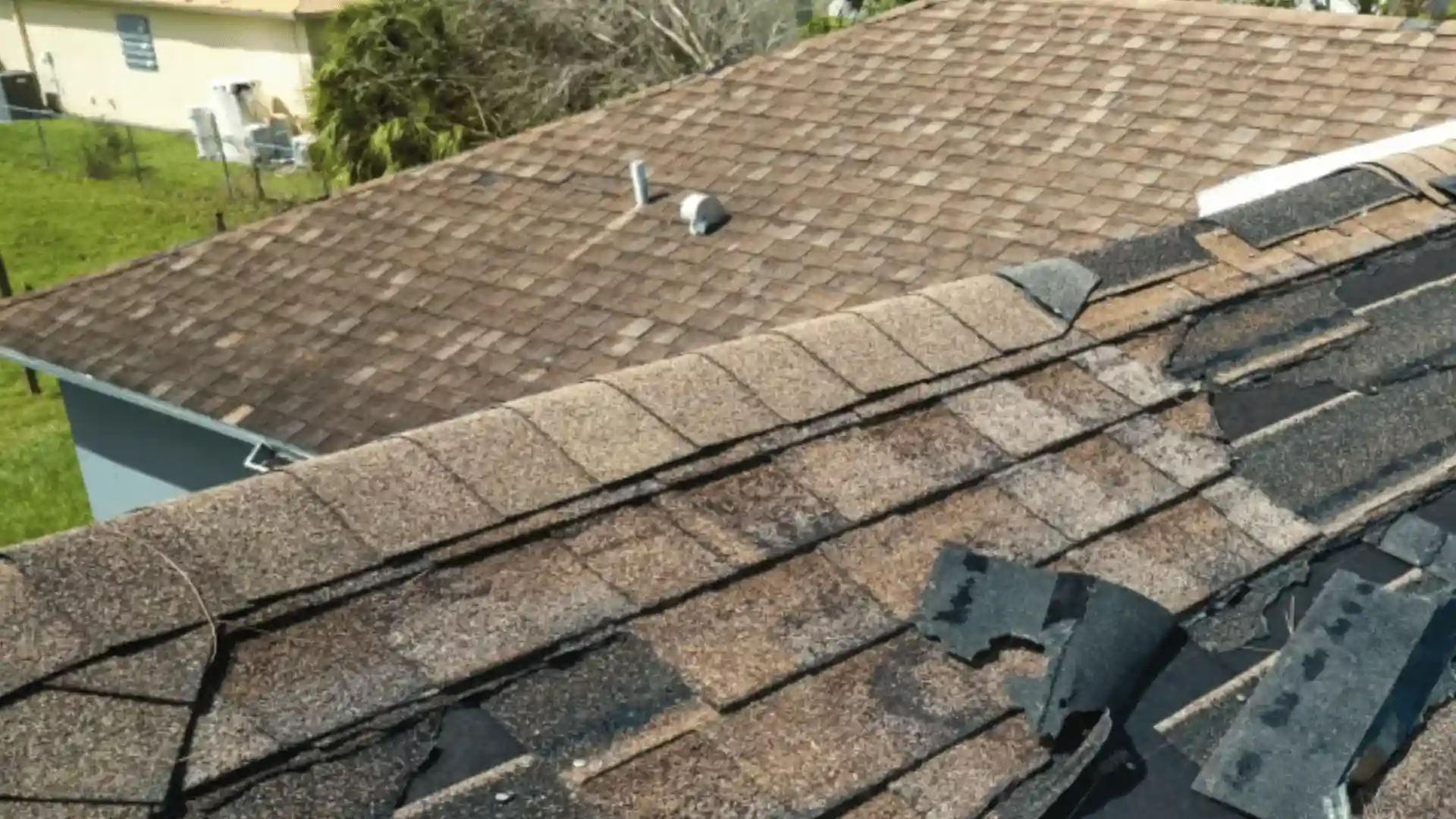 Roof with severely lifted and missing shingles after a storm in Rochester MN requiring immediate inspection