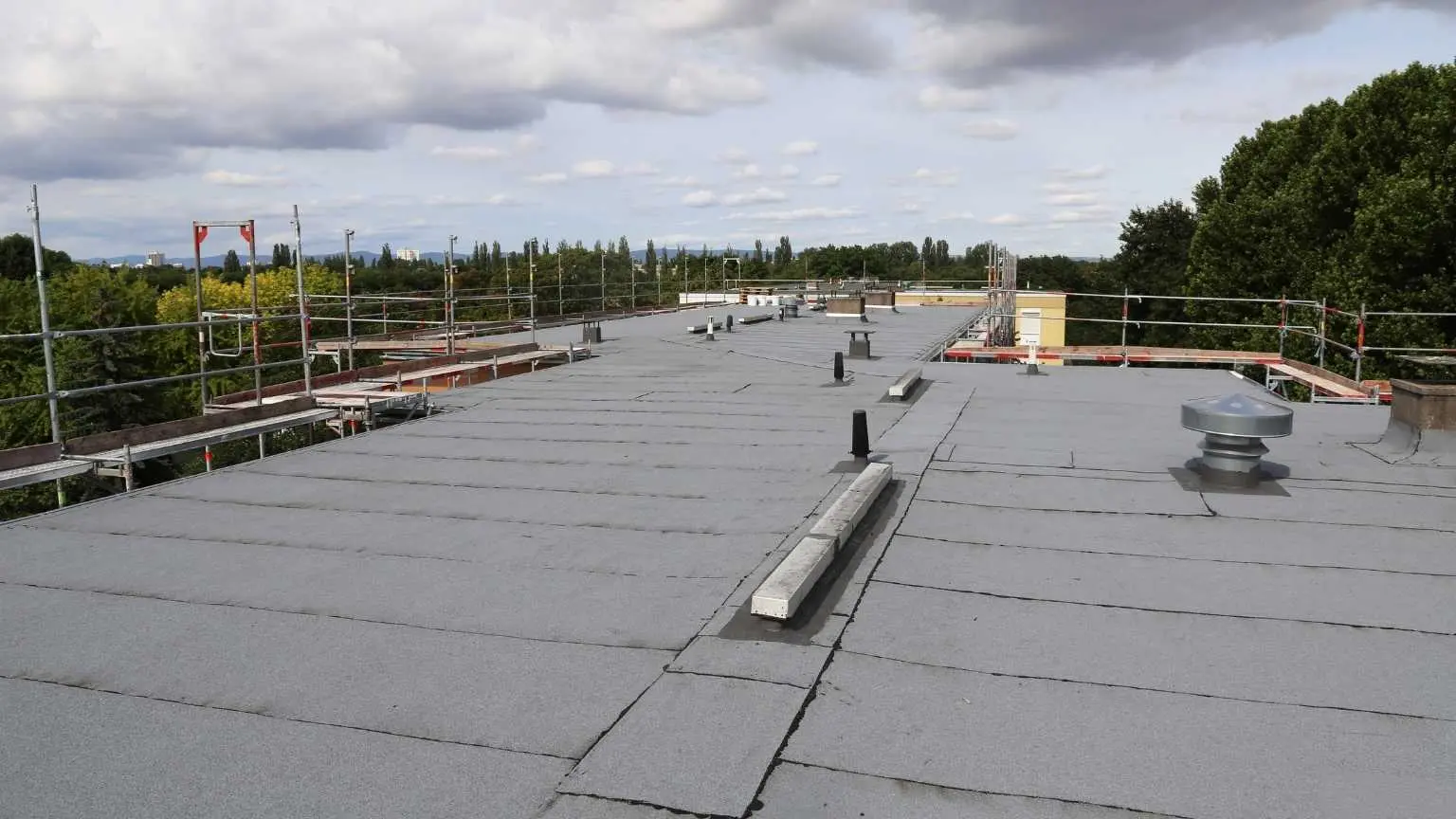 Flat commercial roof showing ponding water and membrane damage