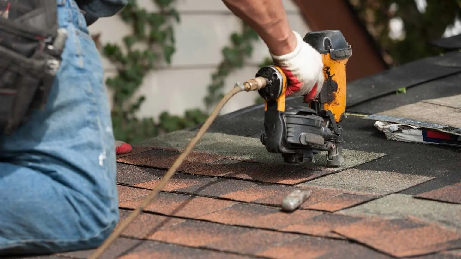 Roofer installing asphalt shingles on a residential roof