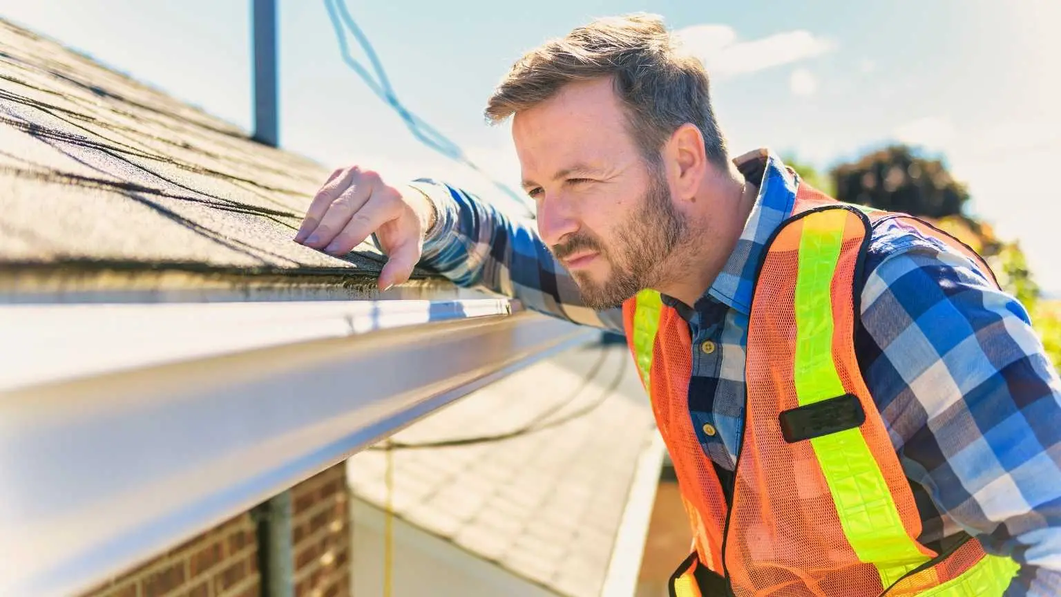 Roofer inspecting a house's roof before starting a project