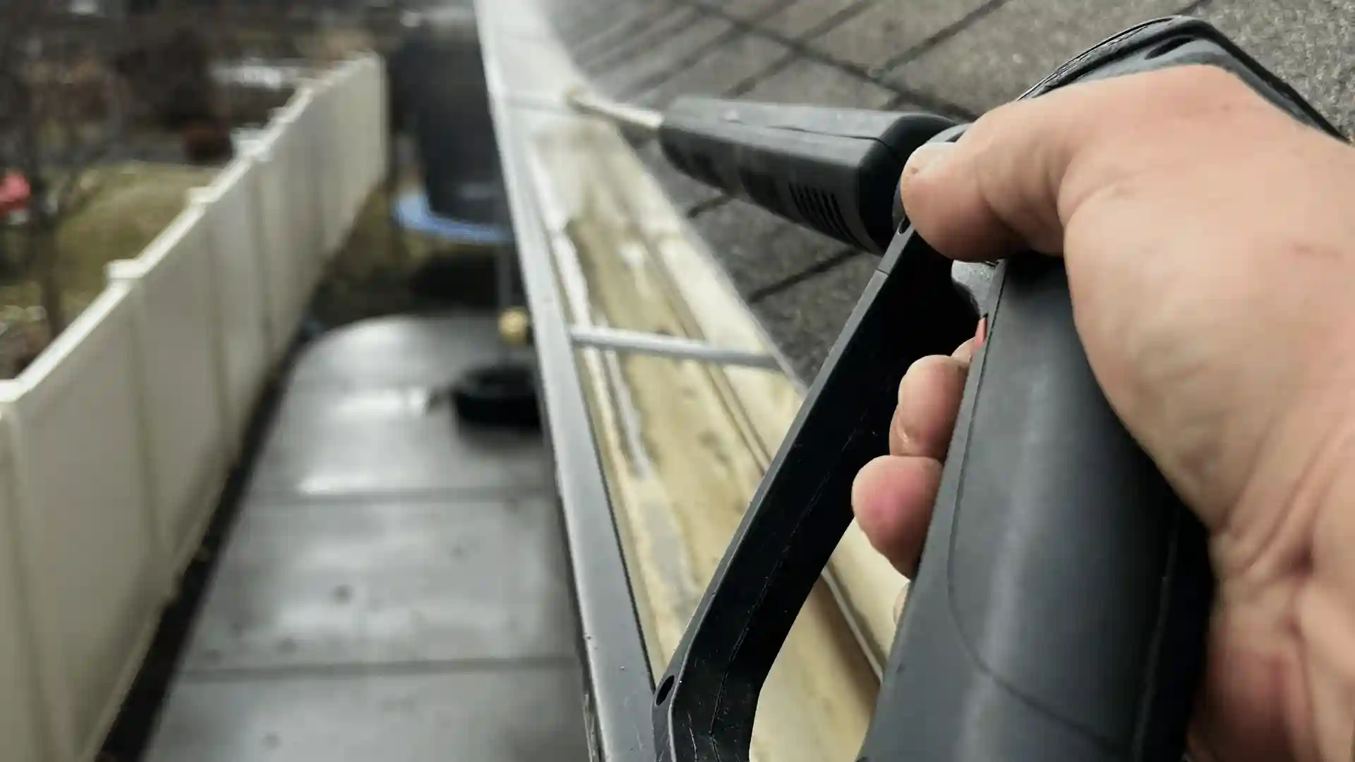 Roofer cleaning clogged gutters to protect roof performance in Rochester MN