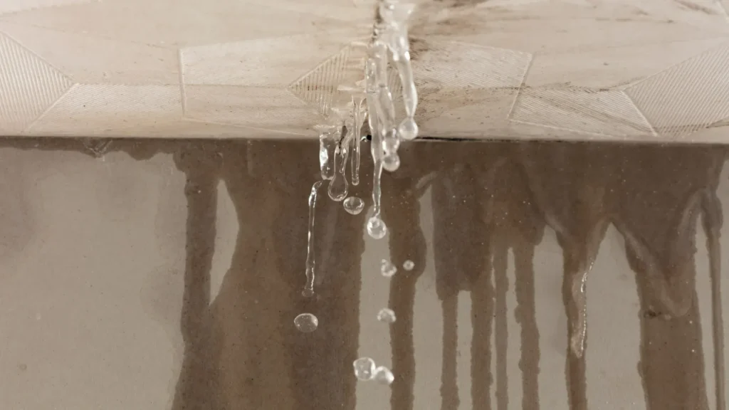 Water leaking through an interior ceiling caused by a roof leak