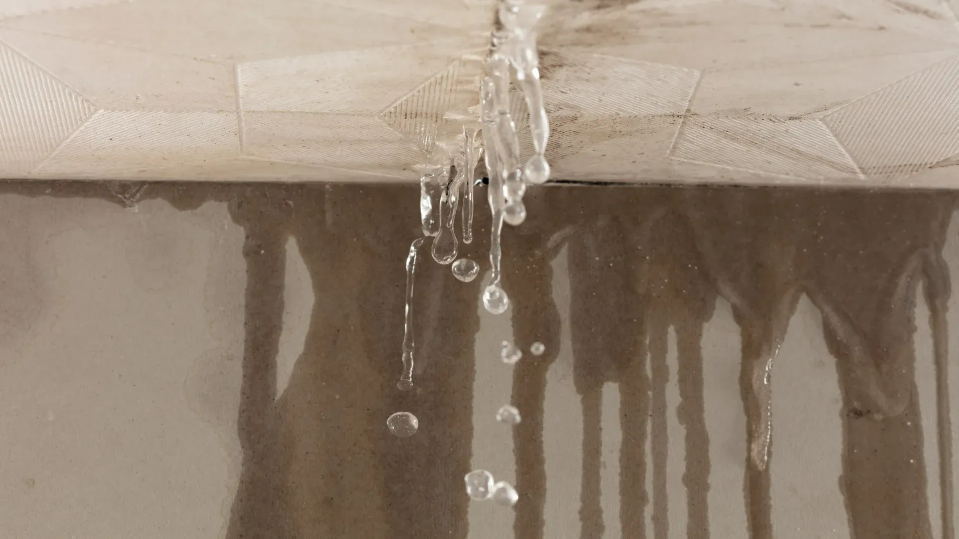 Water leaking through an interior ceiling caused by a roof leak