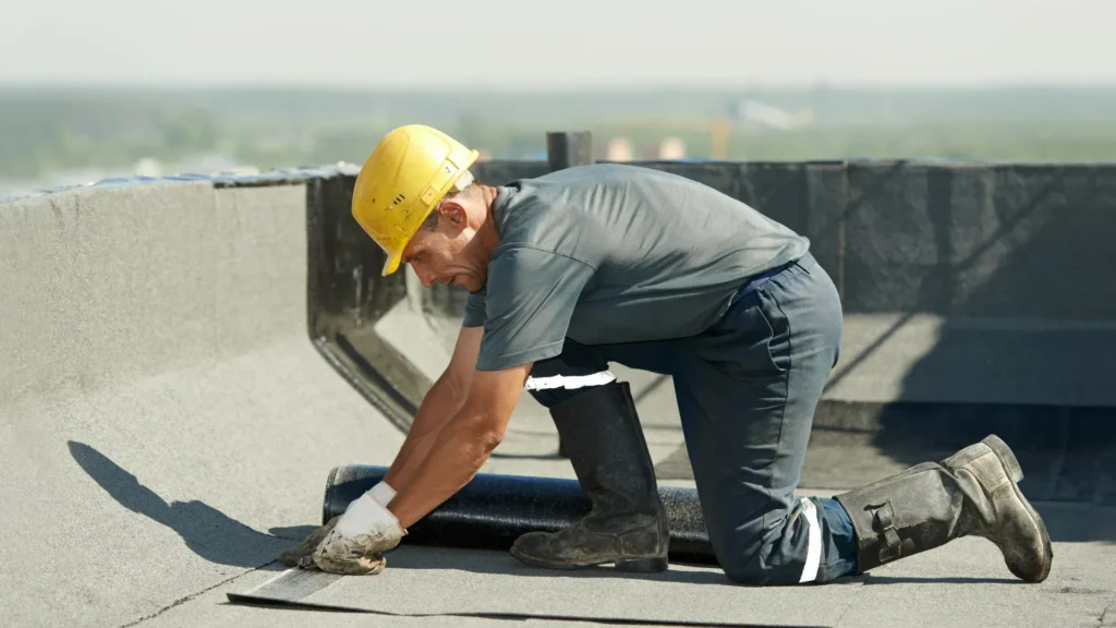 Roofing professional performing preventative gutter maintenance on a residential home
